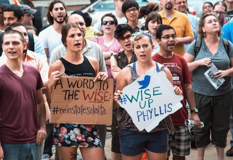 In this Aug. 26, 2014 photo, protesters at the University of Illinois in Champaign, Ill., protest against the school recently rescinding a job offer to an English professor named Steven Salaita to join the university's American Indian Studies program. Salaita had over the summer used Twitter to angrily and sometimes profanely denounce Israel during its conflict with the Palestinians. Salaita now isn't talking. But his supporters say his academic freedom was violated. (AP Photo/The News-Gazette, John Dixon) MANDATORY CREDIT