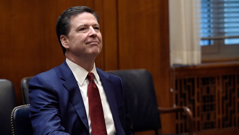 Former FBI Director James Comey now says he tried to hide among the tall, blue curtains adorning a White House meeting room in an attempt to hide from President Trump at an Inauguration Day event. (AP Photo/Susan Walsh, Pool, File)