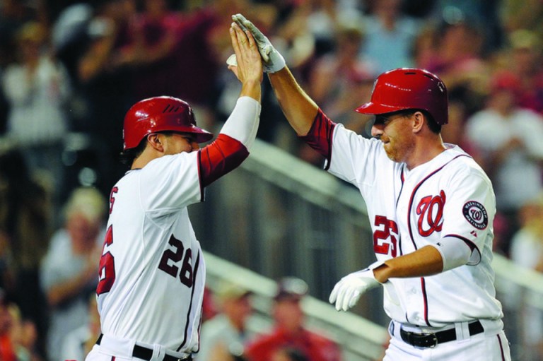 Patrick McDermott/Getty Images
The Washington Nationals' Jesus Flores, left, and Adam LaRoche scored in the sixth inning against the Tampa Bay Rays.
