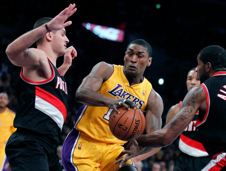   Los Angeles Lakers forward Metta World Peace, center, splits between the defense of Portland Trail Blazers guard Sasha Pavlovic, left, of Montenegro, and Trail Blazers forward LaMarcus Aldridge, right, during the first quarter of an NBA basketball game, Friday, Dec. 28, 2012, in Los Angeles. (AP Photo/Alex Gallardo)  