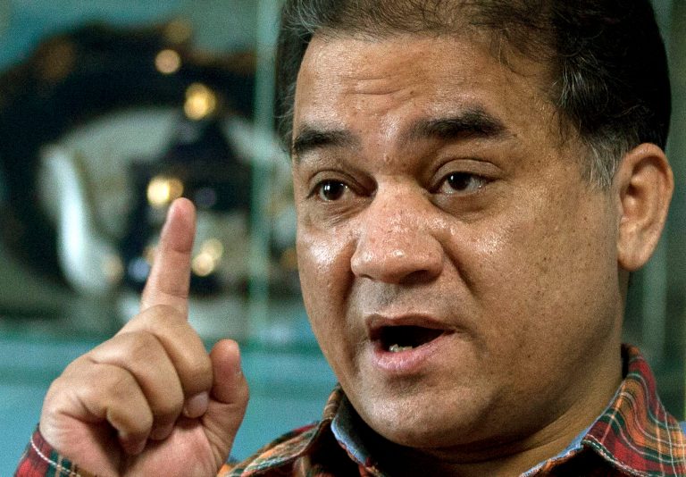 In this Feb. 4, 2013 photo, Ilham Tohti, an outspoken scholar of China's Uighur minority, gestures as he speaks during an interview at his home in Beijing, China. A Chinese court on Tuesday, Sept. 23, 2014 imposed a harsh life sentence on Ilham  Tohti, who championed the country's Uighur minority, the most severe penalty in a decade for anyone in China convicted of illegal political speech. (AP Photo/Andy Wong)