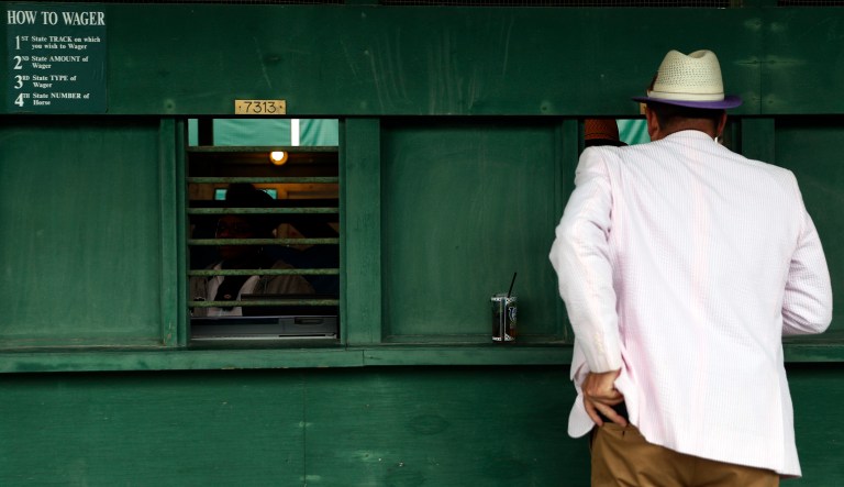 A man places a bet before the 143rd running of the Kentucky Derby horse race at Churchill Downs, Saturday, May 6, 2017, in Louisville, Ky. (AP Photo/John Minchillo)