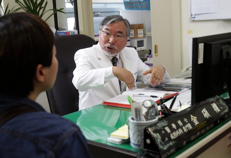HOLD FOR USE WITH STORY SLUGGED SOUTH KOREA TRANSGENDER SURGEON BY HYUNG-JIN KIM, In this March 18, 2014 photo, Dr. Kim Seok-Kwun, 62, talks with an unidentified patient at Dong-A University Hospital in Busan. As Dr. Kim  begins what will be 11 hours of surgery meant to create a functioning penis for a Buddhist nun, he is well aware of the unease his work creates in this deeply conservative country. The devout Protestant known as the âfather of South Korean transgender peopleâ once wrestled with similar feelings.(AP Photo/Ahn Young-joon).