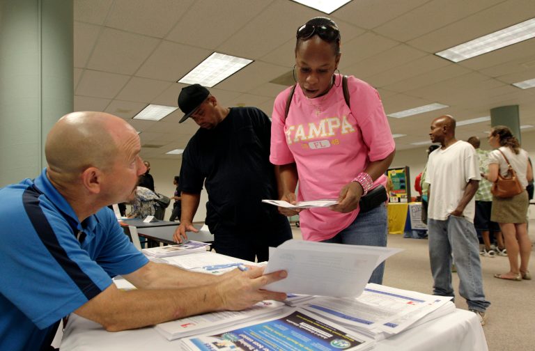In this Wednesday, Aug. 27, 2014 photo, Matthew Kramer, left, an adult work coordinator for Columbus City Schools, talks to Bianca Cunningham, of Columbus, at the work experience program sponsored by the Ohio Association of Food Banks, in Columbus, Ohio. The work experience program helps participants gain valuable job skills and experience through volunteer service. (AP Photo/Jay LaPrete)