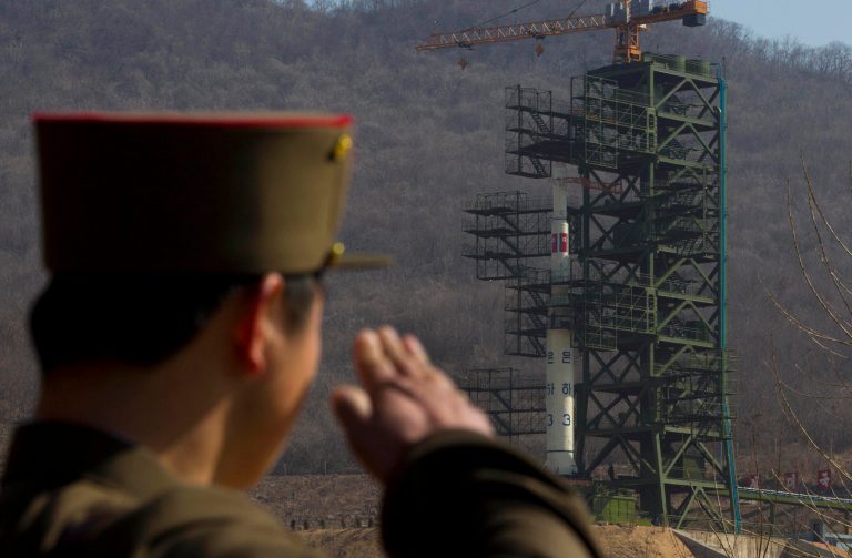   FILE - In this April 8, 2012, file photo, a North Korean soldier salutes in front of the country's Unha-3 rocket, slated for liftoff between April 12-16, at Sohae Satellite Station in Tongchang-ri, North Korea. North Korea may postpone the controversial launch of a long-range rocket that had been slated for liftoff as early as Monday, Dec. 10, 2012, North Korean state media said Sunday, Dec. 9, 2012. North Korea announced earlier this month that it would launch a three-stage rocket mounted with a satellite from its Sohae station southeast of Sinuiju sometime between Dec. 10 and Dec. 22. (AP Photo/David Guttenfelder, File)  