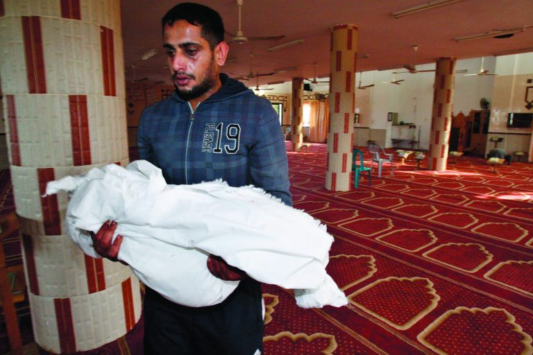 Palestinian Yoused Abu Khoussa, carries the body of his one and a half year-old son Iyad, during his funeral in Bureij Refugee Camp, central Gaza Strip, Sunday, Nov. 18, 2012. The baby boy was one of five Palestinian children killed in Israeli strikes on Sunday, according to a Gaza health official.(AP Photo/Adel Hana)