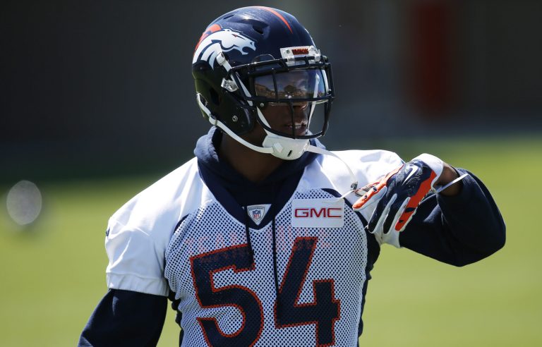 On the Denver Broncos' sideline, linebacker Brandon Marshall took a knee during Andra Day's rendition of the national anthem as all of his teammates stood for the song. (AP Photo/David Zalubowski)