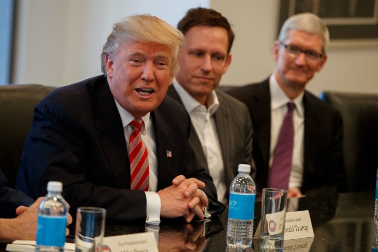 Apple CEO Tim Cook, right, and PayPal founder and Trump advisor Peter Thiel, center, listen as President-elect Donald Trump speaks during a meeting with technology industry leaders in December. At Trump's nominating convention, Thiel helped the candidate's outreach to the LGBT community when he said, 
