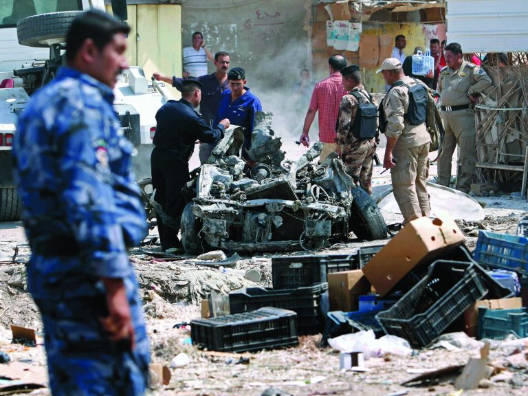 Security forces inspect the scene of a car bomb attack in Basra, 340 miles (550 kilometers) southeast of Baghdad, Iraq, Sunday, Sept. 9, 2012. In violence, which struck at least 10 cities across the nation Insurgents killed at least 39 people in a wave of attacks against Iraqi security forces on Sunday, gunning down soldiers at an army post and bombing police recruits waiting in line to apply for jobs, officials said. (AP Photo/Nabil al-Jurani)