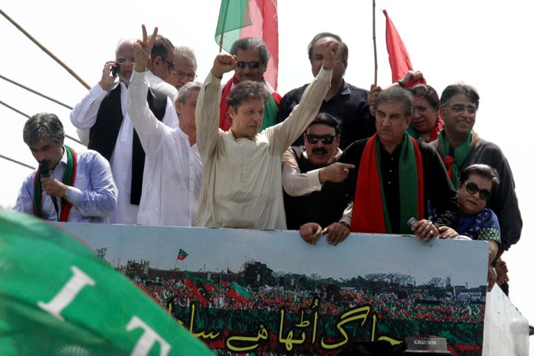 Pakistan's cricketer-turned-politician Imran Khan, center, gestures as he leaves for Islamabad from Lahore, Pakistan, Thursday, Aug. 14, 2014.  Roads leading to the parliament in Islamabad are being blocked in run up to announced protests by Khan and anti-government cleric Tahir-ul-Qadri. Both men want the government to step down and new elections to be held. (AP Photo/K.M. Chaudary)