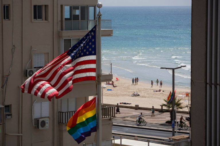 A U.S. flag is raised alongside a pride flag on the U.S. Embassy a day before the Gay Pride Parade in Tel Aviv, Israel, Thursday, June 12, 2014. In June, Tel Aviv celebrates its annual, week-long event that supports lesbian, gay, bisexual, transgender and their supporters, also known as the LGBT community. (AP Photo/Oded Balilty)