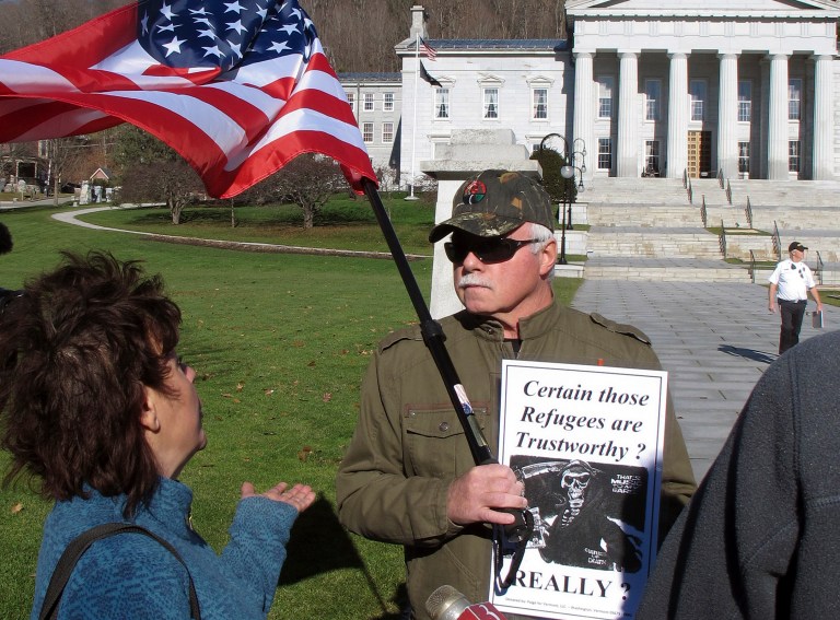 Bronwyn Fryer, left, and Rick Lawrence debate Friday Nov. 20, 2015 in front of the Statehouse in Montpelier, Vt., whether Syrian refugees should be brought to the state. (AP Photos/Wilson Ring)