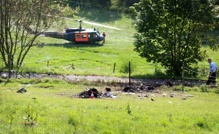 A helicopter has landed near debris of a crashed Learjet near Elpe, Germany, Monday, June 23, 2014. The Learjet with two persons on board collided with a Eurofigher of German airforce which landed safely at its base in Noervenich. (AP Photo/dpa, Joerg Taron)