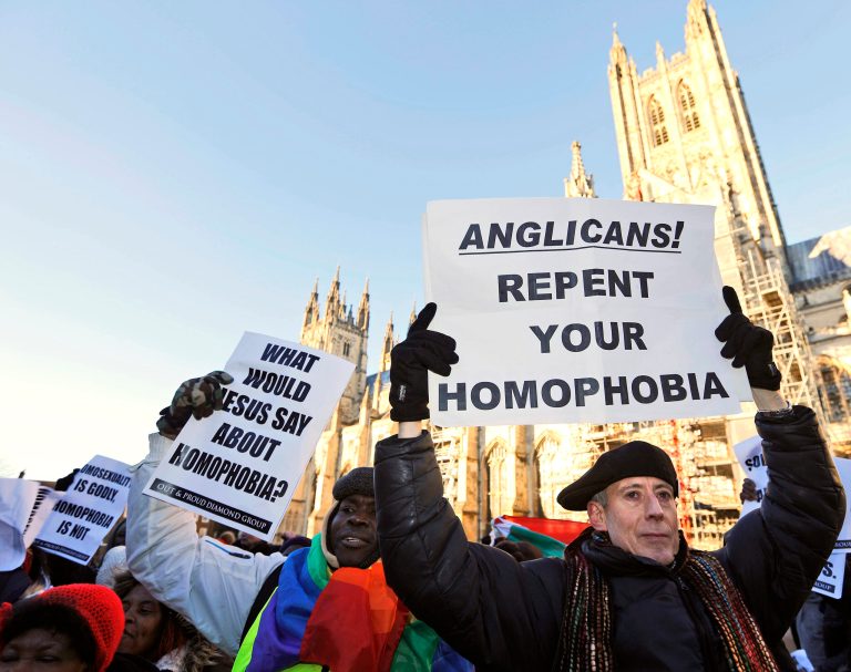 Human rights campaigner Peter Tatchell, right, demonstrates with others against the decision by Anglican Primates to punish pro-gay equality churches in North America, in front of the Canterbury Cathedral in Canterbury, England, Friday, on Jan. 15. (AP Photo/Frank Augstein)