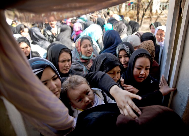 Afghan women push to enter a room to register for the upcoming presidential elections in a school in Kabul, Afghanistan, Tuesday, March 18, 2014. Last minute registration of voters continues despite the fact that more than 21 million voter registration cards have been issued while only roughly 12  million Afghans are eligible to vote. The discrepancy is the result of repeated registrations since the first round of elections in Afghanistan in 2004. (AP Photo/Anja Niedringhaus)