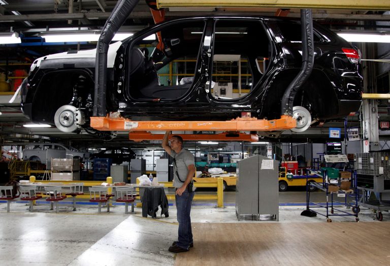   FILE - In this Wednesday, May 8, 2013, file photo, Jeff Caldwell, 29, right, a chassis assembly line supervisor, checks a vehicle on the assembly line at the Chrysler Jefferson North Assembly plant in Detroit. The government reports on worker productivity and labor costs in the April-June quarter on Friday,Aug. 16, 2013. (AP Photo/Paul Sancya, File)  