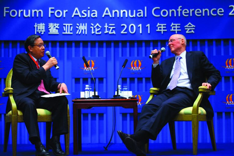 Former Treasury Secretary Hank Paulson, shown with  former Chinese ambassador to the United States Zhou Wenzhong, wants the U.S. to put out the welcome mat to China investment. (Photo by ChinaFotoPress/Getty Images)