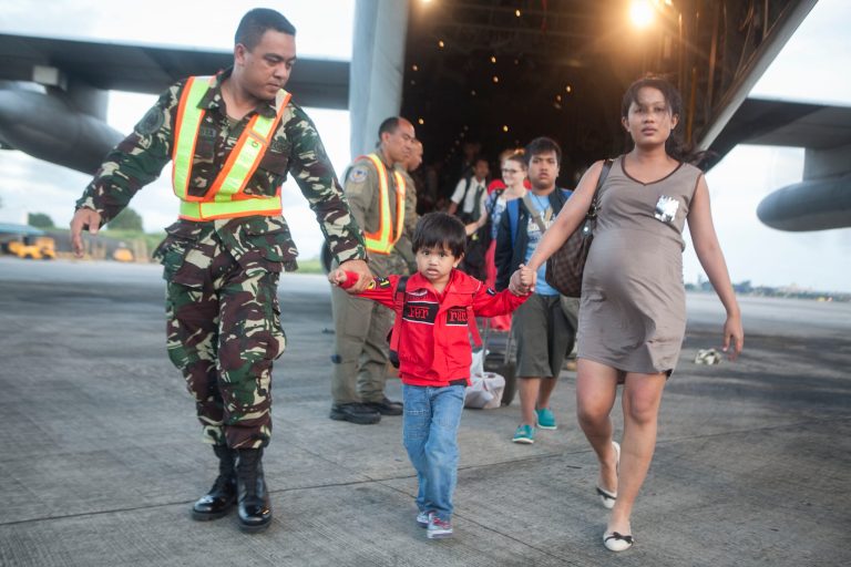 An Airman with the Philippines Air Force helps offload Filipino civilians out of a U.S. Marine Corps C-130 Hercules aircraft at Villamor Air Base, Philippines. U.S. service members are assisting the Armed Forces of the Philippines in the recovery efforts for the people affected in the aftermath of Typhoon Haiyan. (AP Photo/NMCS, Cpl. Codey Underwood)