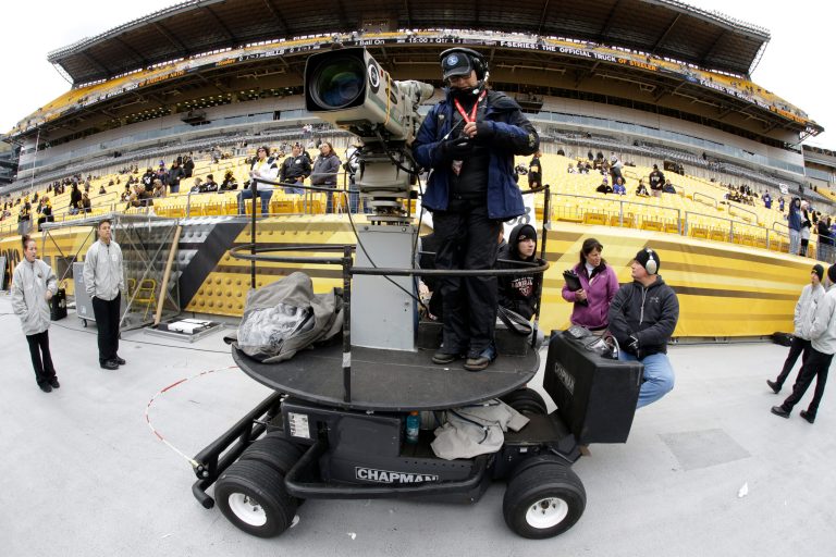 FILE - In this Nov. 10, 2013, file phot, a CBS sideline camera operator prepares for an NFL football game between the Pittsburgh Steelers and the Buffalo Bills in Pittsburgh. The NFL says CBS will televise eight of its Thursday night games next season. The leagues says the contract is for one year, and they have an option to extend it for 2015.  (AP Photo/Gene J. Puskar, File)