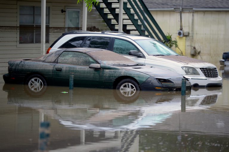 Two cars are covered in sediment as floodwaters recede along Strong Street in Pensacola, Fla., Wednesday, April 30, 2014. ensacola, Florida, got more rain on Wednesday than drought-struck Los Angeles has had in more than two years. (AP Photo/G.M. Andrews)