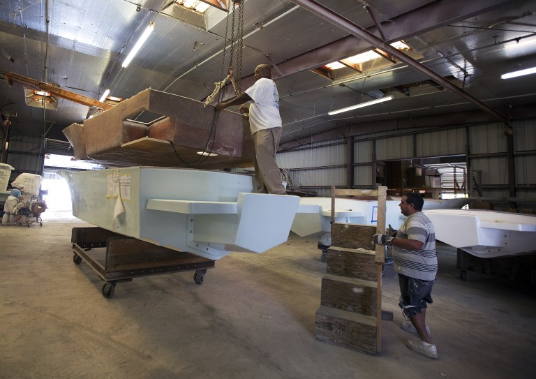 In this Sept. 17, 2014 photo, workers at the Dusky Marine factory in Dania Beach, Fla., begin to assemble one of the custom boats they built at the family owned business. Each year the company makes 50-100 fishing boats. The Commerce Department releases factory orders for August on Thursday, Oct. 2, 2014. (AP Photo/J Pat Carter)