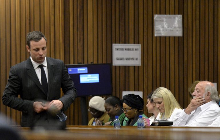 Oscar Pistorius, left, walks past Barry Steenkamp, the father of Reeva Steenkamp, right, during his trial, in Pretoria, South Africa, Friday, Aug. 8, 2014. The chief defense lawyer for Pistorius delivered final arguments in the athlete's   trial on Friday, alleging that Pistorius thought he was in danger when he killed girlfriend Reeva Steenkamp and also that police mishandled evidence at the house where the shooting happened. (AP Photo/ Herman Verwey, Pool)