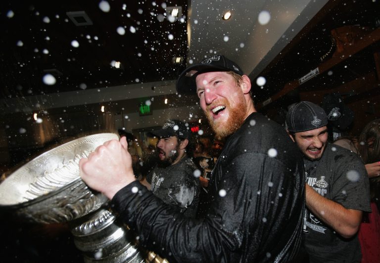   Los Angeles Kings defenseman Matt Greene (2) celebrates with the Stanley Cup in the locker room after the Kings defeated the New Jersey Devils 6-1 in Game Six of the NHL hockey Stanley Cup finals at the Staples Center Monday, June 11, 2012 in Los Angeles. The Kings won the series 4-3. (AP Photo/Dave Sandford/Pool)  