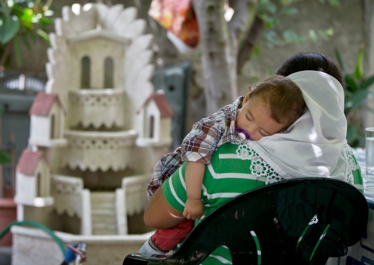 A Roma woman speaks about the hardships faced in camp in Grigny, France, with her back to the camera, fearing identification, during an interview with the Associated Press in Voluntari, outside Bucharest, Romania, on June 25, 2014. One of the inhabitants of the Grigny Roma camp on the northwest edge of Paris, a teenage boy named Darius, was beaten into a coma, apparently by residents of a neighboring housing project. Within hours, the Roma vanished, seeking sanctuary in a new location on the fringes of one of the world's wealthiest cities. Three weeks later, 16-year-old Darius remains unconscious. His family is in hiding. Police have made no arrests. France is coming under increasing pressure to answer allegations that it is encouraging harassment of Europe's poorest minority group in hopes that the Roma, also known as Gypsies, will leave the country. (AP Photo/Vadim Ghirda)