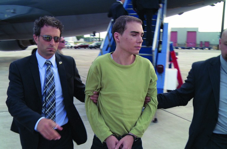 In this photo provided by Montreal Police, Luka Rocco Magnotta is taken by police from a Canadian military plane to a waiting van on Monday, June 18, 2012, in Mirabel, Quebec. Magnotta, the suspect in the killing and dismemberment of a Chinese student, returned to Canada via military transport from Germany, where he was arrested this month. (AP Photo/Montreal Police)