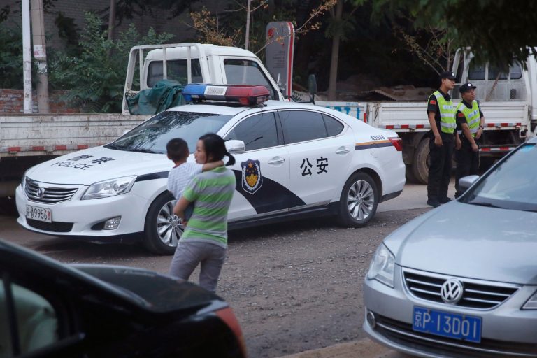 Chinese security guards stand on duty near a police car at a junction leading to the venue for the Beijing Independent Film Festival in Beijing Saturday, Aug. 23, 2014.  Chinese authorities blocked the annual independent film festival from opening on Saturday, said organizers of an event that has become a rare and influential venue for the showing of films that could be critical of the government. (AP Photo/Ng Han Guan)