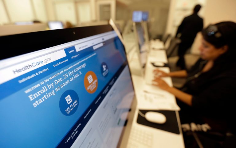 FILE - In this Dec. 11, 2013 file photo, Rosemary Cabelo uses a computer at a public library to access the Affordable Health Care Act website, in San Antonio. The Obama administration says following a December surge, more than 1.1 million people have now enrolled for health insurance through the federal government's improved website. (AP Photo/Eric Gay, File)