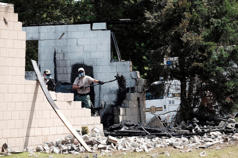Officials use a shovel as they investigate the burned Glover Grove Baptist Church in Warrenville, S.C. on Friday, June 26, 2015. (Todd Bennett/The Augusta Chronicle via AP)