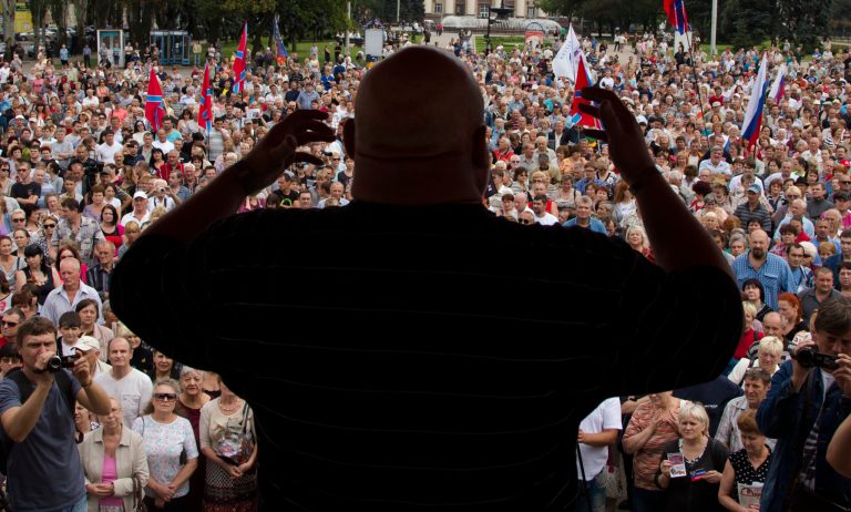 People listen to a pro-Russian activist during a pro-Russian meeting in the city of Donetsk, eastern Ukraine Sunday, July 6, 2014. More than a thousand people rallied on Donetsk's central Lenin square on Sunday afternoon in support of the pro-Russian rebellion after an important defeat yesterday. (AP Photo/Dmitry Lovetsky)