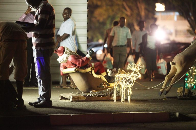   In this photo taken late Thursday Dec. 20, 2012, people walk past Christmas decorations at a shopping mall in Harare, Zimbabwe. Zimbabwe will join the rest of the world in celebrating the Christmas season in a manner that reflects its tradition and culture. Thousands of people are set to travel across the country to be with their families in rural areas. (AP Photo/Tsvangirayi Mukwazhi)  