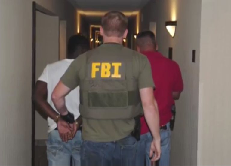 In this June, 2014 image from video provided by the FBI, authorities raid a hotel in Jackson, Mississippi.  When FBI agents and police officers fanned out across the country last month in a weeklong effort to rescue child sex trafficking victims, they pulled kids as young as 11 from dingy motel rooms, truck stops and homes. (AP Photo/FBI)