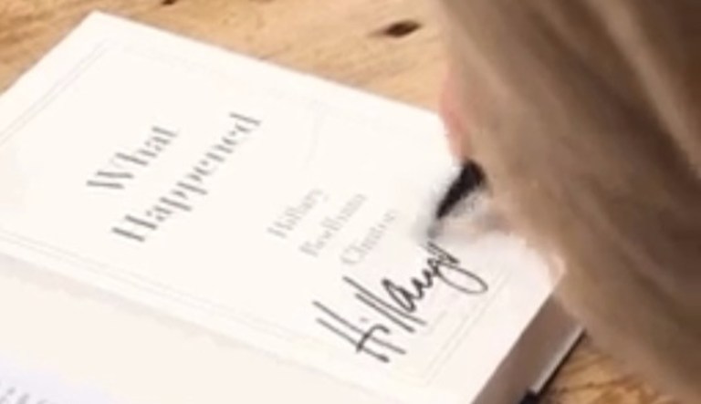 In a tweet, Hillary Clinton showed herself signing the last copy of her memoir on her book tour. In the book, Clinton details her experiences as the 2016 Democratic presidential nominee running against then-candidate Donald Trump. (screenshot)