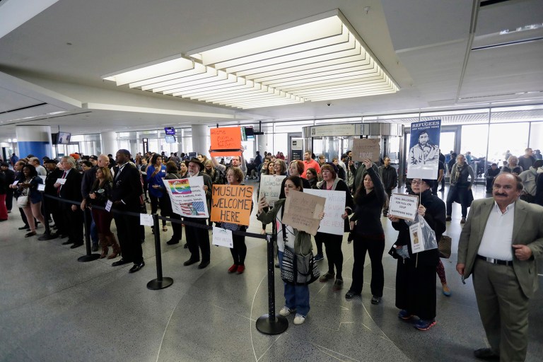 Protesters hold signs at airports to denounce President Trump's executive order that bars citizens of seven predominantly Muslim-majority countries from entering the U.S. Trump on Wednesday weighed in on whether his Friday executive order amounts to an immigration 