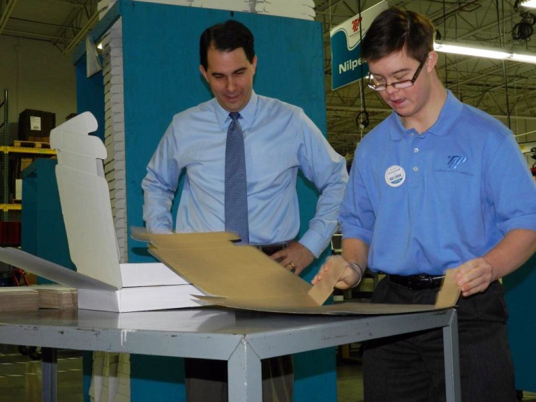 Wisconsin Gov. Scott Walker, left, visiting with Patrick Young at Tailored Label Products in Menomonee Falls. Young has Down Syndrome. Walker says meeting Young inspired Walker to launch an initiative to expand opportunities for workers with disabilities. (AP/Tailored Label Products)