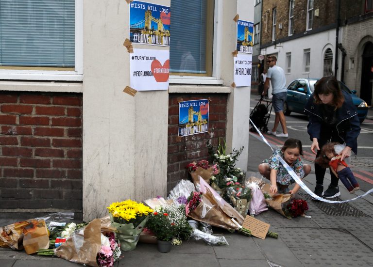 A small child lays flowers at a corner tribute in the London Bridge area of London, Sunday, June 4, 2017. Police specialists collected evidence in the heart of London after a series of attacks described as terrorism killed several people and injured more than 40 others. (AP Photo/Frank Augstein)