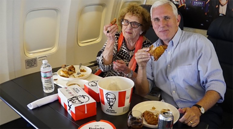 Mike Pence tweeted a photo Monday night of him and his mother, Nancy, aboard Trump's private jet with a table full of fried chicken, biscuits and fixings. (Photo courtesy of Mike Pence, via Twitter)
