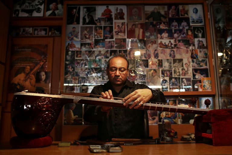   Indian traditional instrument craftsman Sanjay Sharma places a fret on a sitar at his store Riki Ram's Music in New Delhi, India, Thursday, Dec. 13, 2012. For close to a 100 years Sharma's family has created musical instruments for legendary Indian musicians. But none more famous than sitar virtuoso Ravi Shankar who died Tuesday at age 92. Described as 