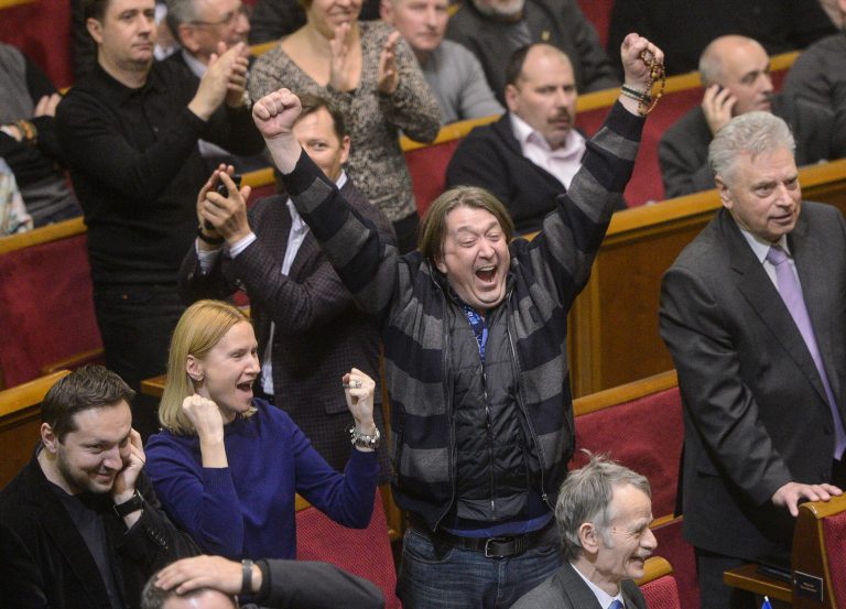 Ukrainian lawmakers celebrate after voting new laws in parliament in Kiev, Ukraine, Friday, Feb. 21, 2014. In a fast-moving day that could change Ukraine's political destiny, opposition leaders reached a deal Friday with the country's beleaguered president, and parliament changed the constitution and opened the way for the release of ex-Prime Minister Yulia Tymoshenko.(AP Photo/Andrew Kravchenko, pool)