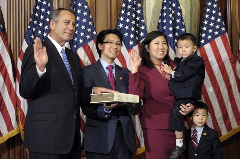 FILE - In this Jan. 3, 2013, file photo, House Speaker John Boehner of Ohio, left, performs a mock swearing in for Rep. Grace Meng, D-N.Y., right, on Capitol Hill in Washington as the 113th Congress began. Meng, a freshman Democrat representing the New York City borough of Queens, was hit in the head and robbed in Washington on Nov. 19, but was not seriously injured and is back to work. Meng said that she suffered a bruise on her chin and scratches on her arm and knee in the attack Tuesday night near Eastern Market in the Capitol Hill neighborhood. (AP Photo/Cliff Owen, File)