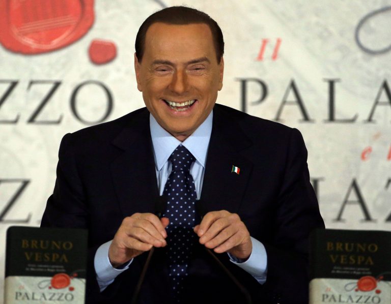   FILE - A Wednesday, Dec. 12, 2012 photo from files showing People of Freedom party leader Silvio Berlusconi smiling as he speaks during a book presentation of Italian journalist Bruno Vespa 