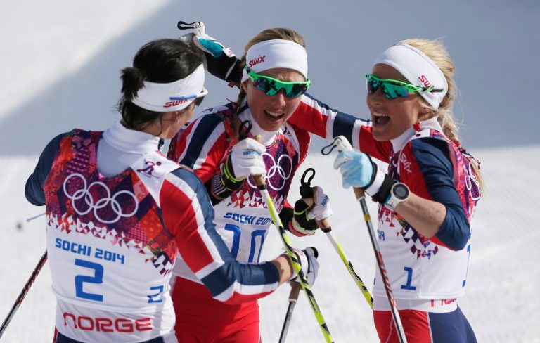 Norway's gold medal winner Marit Bjoergen, left,  congratulates Norway's bronze medal winner Kristin Stoermer Steira and Norway's silver medal winnerTherese Johaug, right, after the women's 30K cross-country race at the 2014 Winter Olympics, Saturday, Feb. 22, 2014, in Krasnaya Polyana, Russia. (AP Photo/Matthias Schrader)
