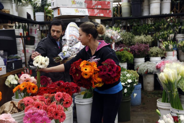 FILE - In this Feb. 14, 2014, photo, buyer Steve Moren, left, examines flowers for purchase for his girlfriend for Valentine's Day, at the Flower Market in Los Angeles. The Conference Board releases the Consumer Confidence Index for February, on Tuesday, Feb. 25, 2014. (AP Photo/Nick Ut, File)