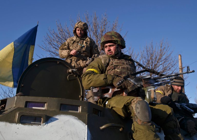 Ukrainian troops ride on an armored vehicle outside Artemivsk, Ukraine, while pulling out of Debaltseve, Wednesday, Feb. 18, 2015. (AP Photo/Vadim Ghirda)