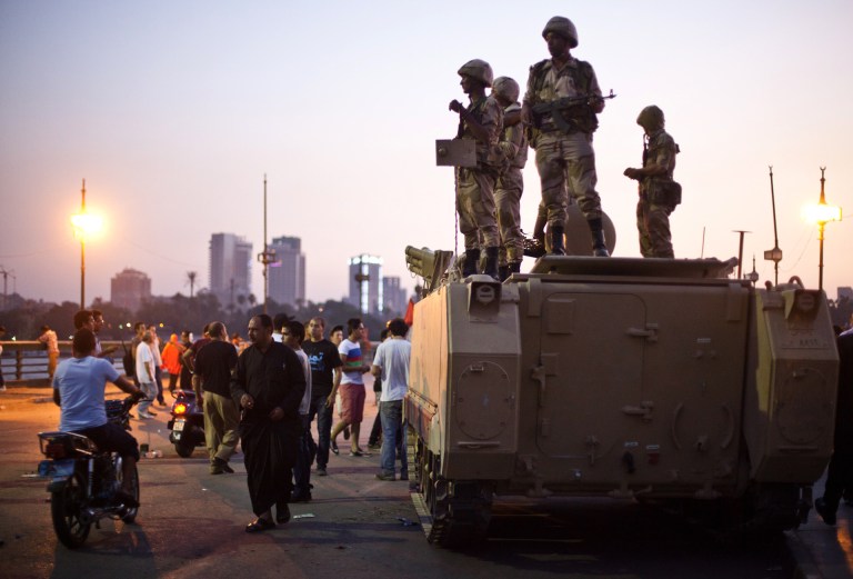 An Egyptian military convoy arrives at the Kasr El-Nile Bridge near Tahrir Square in order to be between supporters and opponents of ousted president Mohammed Morsi in Cairo, Egypt, Friday, July 5. White House Press Secretary Jay Carney told reporters that the United States has not decided if a coup took place in Egypt last week. (Virginie Nguyen Hoang/AP)