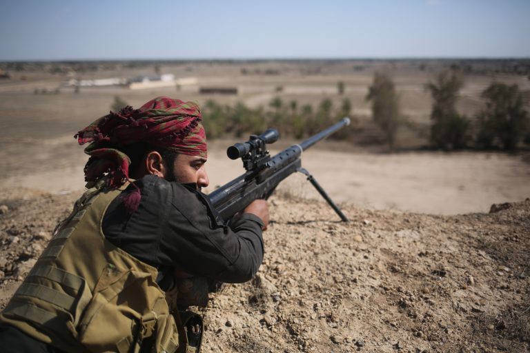 A Shia militia sniper from Abo al Fadhel al Abbas provides cover for Iraqi Army troops as they assault Islamic State fighters on the frontline April 14, 2015 near Al-Karmah, in Anbar Province, Iraq. (Getty Image)