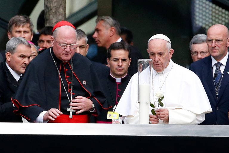 Pope Francis prepares to lay a flower on the edge of the South Pool at the World Trade Center in New York, Friday, Sept. 25, 2015. Pope Francis is on a five-day trip to the United States. (AP Photo/Julio Cortez, Pool)